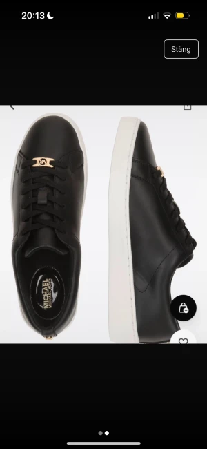 Svarta sneakers från Michael Kors - Snygga svarta sneakers från Michael Kors med vit platt sula och guldfärgad MK-detalj vid snörningen. Skorna har rund tå och är tillverkade i slätt skinn med klassisk snörning. Perfekta för dig som gillar stilrena och trendiga skor.