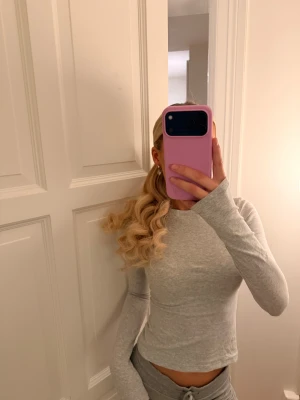 Långarmad tröja från SKIMS - Säljer en ljusgrå långärmad tröja från SKIMS, knappt använd. Nypris 795kr