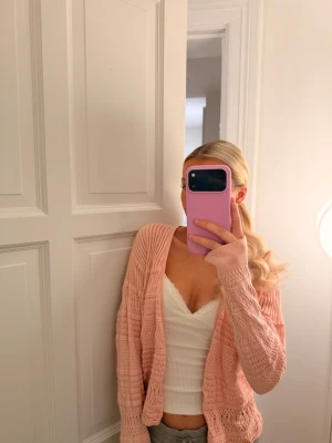 Ljusrosa stickad kofta  - Säljer en ljusrosa stickad kofta. Koftan har ett luftigt och öppet stickat mönster.