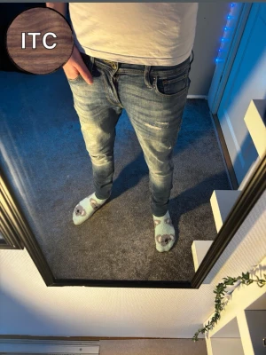 Jack & Jones Jeans  - Säljer ett par Jack & Jones jeans med slitningar och hål på benen för en riktigt avslappnad vibe. Jeansen har klassisk femficksdesign, låg midja och är tillverkade i mjukt denimtyg. Perfekta för dig som gillar en slim passform och lite ruffig look.