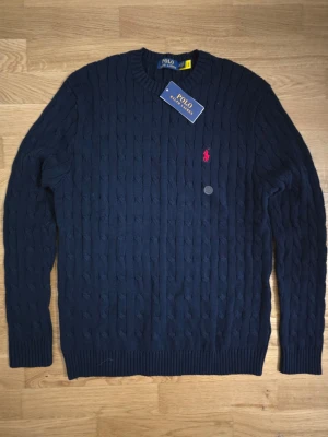 Ralphlauren kabelstickad tröja - En marinblå kabelstickad tröja från Ralph lauren i storlek M för ett jätte billigt pris.
