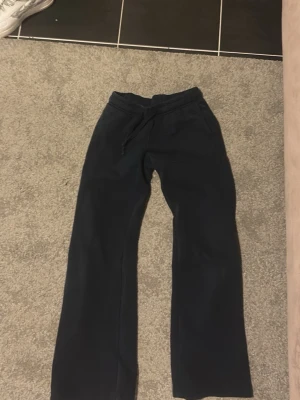 Svarta mjukisbyxor från Gina Tricot - Mysiga svarta mjukisbyxor från Gina Tricot med dragsko i midjan och raka ben. Byxorna har två bakfickor och är gjorda i mjukt material som passar perfekt för chill dagar. Klassisk och enkel design som är lätt att matcha.