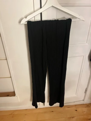 Svarta ribbade byxor från Lindex  - Säljer ett par svarta ribbade byxor från Lindex i storlek XS. Byxorna har elastisk midja och är gjorda i ett mjukt material med raka ben. Perfekta för en chill och avslappnad look.