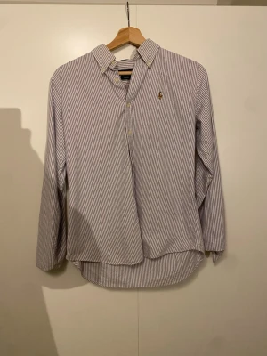 Randig skjorta/ Ralph Lauren - Klassisk skjorta från Ralph Lauren i vit och blå randig design. Den passar M men sitter lika bra på S bra skick inga defekter