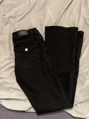 Svarta bootcut jeans från Gina Tricot - Svarta lågmidjade bootcut jeans från Gina med fickor där bak. Använda 1 gång 