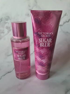 Victoria's Secret Sugar Blur duo - Setet Sugar Blur från Victoria's Secret innehåller en body mist (250 ml) och en body lotion (236 ml). Beskrivs med toner av vispad vaniljsocker, amber och hallon. Perfekt för dig som vill ha en söt och fräsch känsla hela dagen. Bodylotion helt ny och oanvänd misten endast provsprayad se bild för mängd