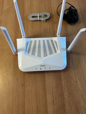 D-Link R15 Trådlös Router med förstärkare - D-Link trådlös router med fyra externa antenner för stark täckning. Kan generera över 1000mbps. Inkluderar strömadapter och nätverkskabel. Utrustad med 3 LAN-portar, 1 WAN-port och WPS-knapp. Mycket gott skick, inga synliga defekter eller slitage.