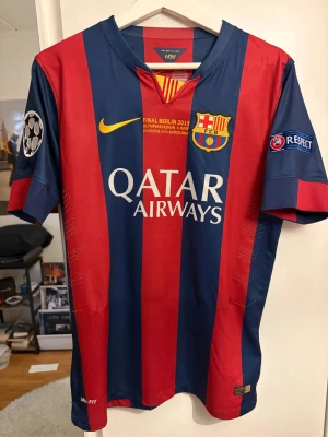 Barça Messi 10 matchtröja 2015 - Säljer en ikonisk FC Barcelona matchtröja från Champions League-finalen 2015 med Messi 10 på ryggen. Tröjan har breda marinblå och röda ränder, gula detaljer och officiella tryck. Tillverk sopolyester med Dri-FIT-teknik för bästa komfort. Helt nytt skick och väldigt sällsynt. Priset är ej hugget i sten