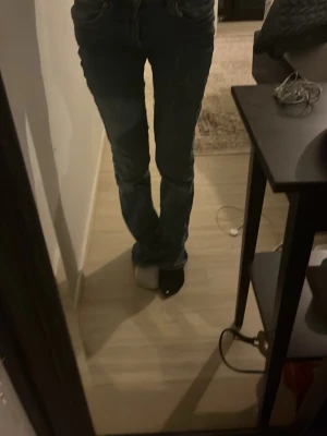 Blå utsvänga jeans med normal midja - Säljer ett par klassiska blå jeans med utsvängda ben och normal midja. Jeansen har 2 fickor och stängs med dragkedja och knapp. Perfekta till vardagslooken och passar till det mesta. Materialet är slitstarkt jeans i bomull.