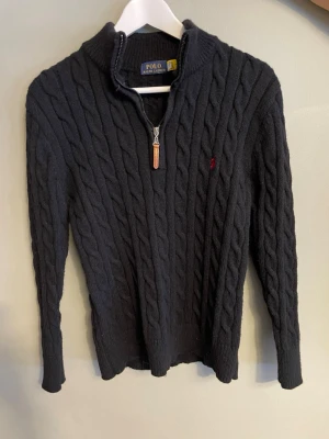 Svart stickad tröja Polo Ralph Lauren - Helt ny och oanvänd half zip från Ralph lauren. Tvättad en gång men aldrig använd. 