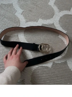 Svart bälte med silverdetalj  - ett svart bälte med två runda silverfärgade ringar som spänne. Typ aldrig använd då jag inte använder bälte💕har lagt ut redan men för 15kr men lägger ut igen då de är fri frakt