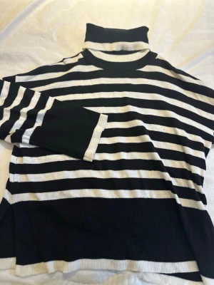 Randig polotröja från VILA XS - Säljer en svartvit randig polotröja från VILA i storlek XS. Tröjan har hög polokrage, långa ärmar och är stickad i mjukt material. Perfekt för dig som gillar klassisk stil med en twist.