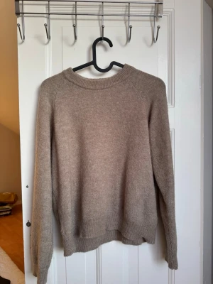 Beige stickad tröja från Zara - Mysig beige stickad tröja från Zara i storlek S. Tröjan har rund halsringning, långa ärmar och ribbade muddar vid ärmslut och nederkant. 