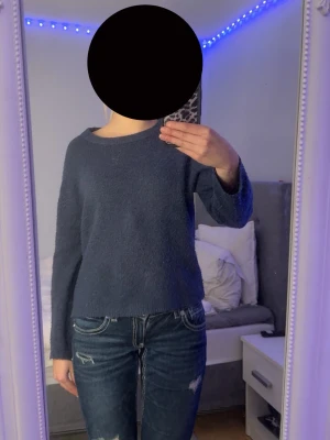 Blå stickad tröja från 157, XS - Mysig blå stickad tröja från 157 i storlek XS. Tröjan har en enkel, rak passform med rund halsringning och långa ärmar. Materialet är mjukt och lite fluffigt, perfekt för kyligare dagar. Den är lite nopprig!