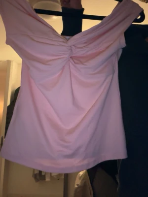 Ljusrosa omlott tubtopp från Amisu - Säljer en ljusrosa tubtopp från Amisu i storlek S. Toppen har omlottdetalj framtill med snygg twist och breda axelband som ger en offshoulder-look. Materialet är mjukt och stretchigt, perfekt för sommardagar eller när du vill ha en söt och enkel topp.💞💞💞