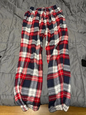 Rödblå rutiga byxor i bomull - Mysiga byxor i röd, blå och vit rutig design från Cubus, Tillverkade i mjuk bomull med resår i midjan och avslappnad passform. Storlek S