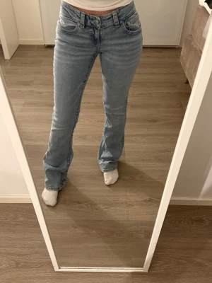 Ljusblå bootcut jeans från gina - Säljer två par bootcut jeans i ljusblå och grå från gina tricot i storlek 36. Jeansen har klassisk femficksdesign, låg midja och är tillverkade i mjukt denimtyg. Snygg tvättad look och raka bakfickor med knappdetalj.
