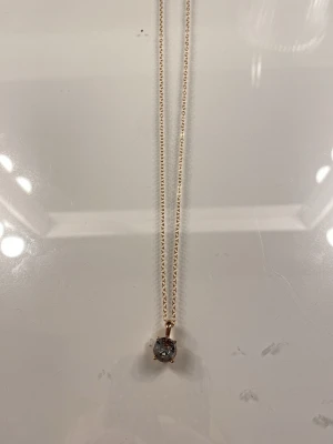 Ingen väst på bilderna - Bilderna visar ett halsband med guldfärgad kedja och en rund klar sten 🩷💞