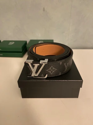 Svart bälte med silverspänne  - Säljer ett snyggt nytt bälte med silverspänne, med bältet följer det med en låda och en Håltagare