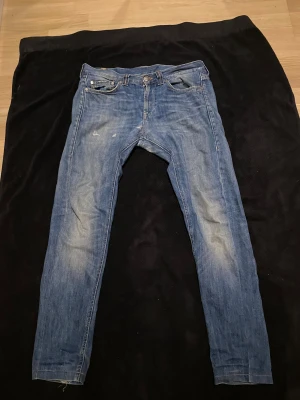 Dondup ljus blå  - Säljer ett par Levis 511 jeans i klassisk blå tvätt med slitningar och skinny passform. Jeansen har fem fickor, knapp och dragkedja fram samt smal siluett hela vägen ner. Materialet är jeans med lätt stretch för extra komfort.