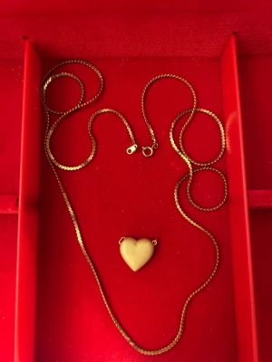 Guldhalsband med hjärthänge - Snyggt halsband i guld med ett stilrent hjärthänge. Kedjan har en klassisk design och hjärtat är matt och mjukt rundat. Perfekt för dig som gillar enkla men personliga smycken med lite romantisk vibe.