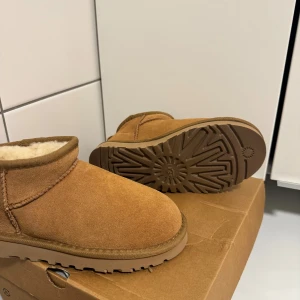 Uggs ultra mini chestnut 36 - Brunbeiga uggs i storlek 36, färgen chestnut. Oanvända då jag köpte dessa inför vintern men inser att jag inte använder dom. Köptes för 2099kr. Kan hämtas upp i Kungsbacka! 