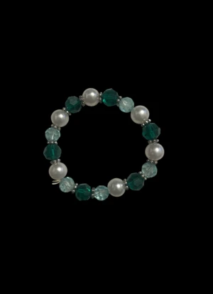 Pärlarmband med gröna och vita pärlor - Snyggt armband med växlande vita pärlor och gröna, facetterade glaspärlor. Armbandet har en rund form och elastisk tråd som gör det enkelt att ta på och av. Perfekt för dig som gillar färg och vill ha något unikt på handleden.