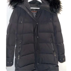 Vinterjacka Hollies - Pris kan diskuteras. Orginalpris 3700-5200. Nyskick. Inga fläckar, hål eller andra defekter. Justerbar luva samt avtagbar krage i fuskpäls. Värmer bra & har innerficka samt djupa fickor där fram som får plats med mycket.