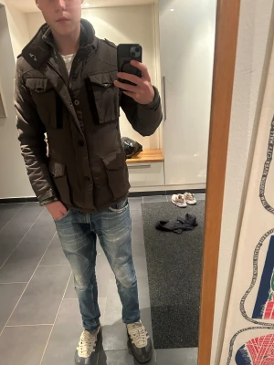 Schott grön fieldjacket fodrad - Schott fieldjacket i grönt  med fyra stora fickor framtill. nypris 2599 mitt pris 1099 endast använd 1 vinter. Det är en pilot inspirerad jacka perfekt för dig med lite avslappnad och finare still den har ett extra lager som man kan ta av och på som du ser på de två sista bilderna 