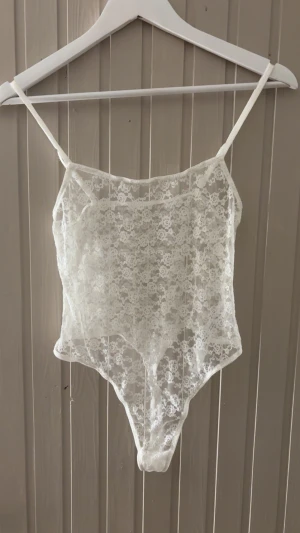 Vit spetsig blommig linnebody - Säljer en superfin vit linnebody i transparent spets med blommigt mönster. Toppen har tunna justerbara axelband och är figurnära med hög benskärning. Perfekt för lager-på-lager eller som statement-piece. Passar dig som vanligtvis använder S/M. Köptes på Urban Outfitters för ca 400 kr💕Använd vid ett tillfälle.                           Hör gärna av dig vid intresse! 