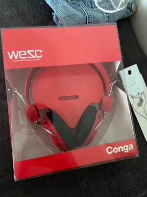 Hörlurar - WESC Conga True Red kabelanslutna over-ear hörlurar. Helt nya, röda hörlurar i förpackning. Väldigt enkla att använda och perfekta för dagligt användande. 