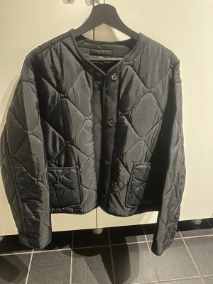 Svart quiltad jacka från Zara - Säljer en svart jacka från Zara i storlek L. Jackan har en normal passform, stora fickor framtill och stängs med knappar. Materialet är syntet och jackan har ett mönster av stora rutor. Perfekt för dig som gillar en chill och trendig look. Jag brukar ha M i jackor men köpte denna i L för att jag ville ha en större passform. Aldrig använd. Pris kan diskuteras🌟