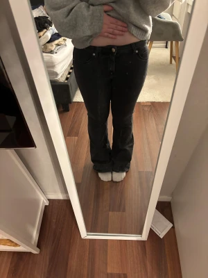 Svarta bootcut jeans från H&M Divided - Säljer ett par svarta bootcut jeans från H&M Divided i storlek 40. Jeansen har klassisk femficksdesign, låg midja och rå kant längst ner på benen för en edgy vibe. Materialet är mjukt och stretchigt jeans, perfekt för dig som gillar bekväma och snygga byxor. MIDJEMÅTT 76cm. INNERBENSLÄNGD 79cm.