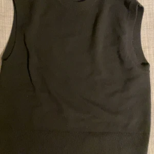 Stickad vest - Säljer en stilren svart stickad väst från Weekday i storlek S. Perfekt för lager-på-lager looken under höst och vinter. Västen har en ribbad kant nedtill och är i mycket bra skick. Passar både till vardags och festliga tillfällen. Använd 1 gång så den är helt i nyskick.