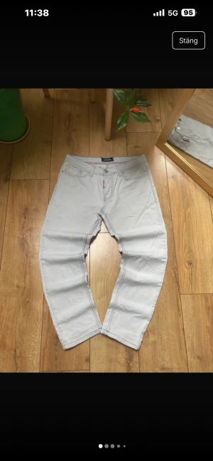Ljusgrå jeans från Dsquared2 - Säljer ett par ljusgrå jeans från Dsquared2. Byxorna har normal passform. Snygg detalj med Dsquared2-logga på knapp och etikett vid gylfen.