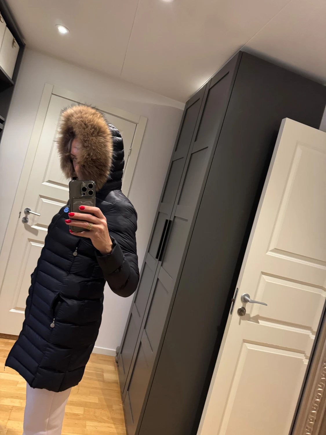 Svart dunjacka med päls på huvan