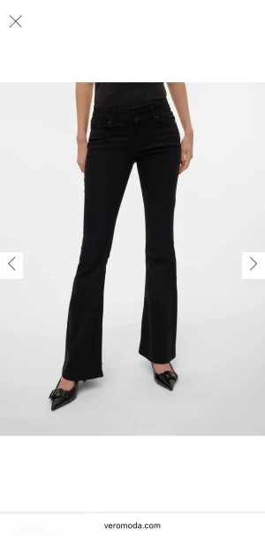 Svarta lågmidjade bootcut jeans från Vero Moda - Snygga svarta lågmidjade jeans från Vero Moda med bootcut passform och klassisk femficksdesign. De är i storlek XS med längden 30 och har en låg midja. Byxorna är tillverkade i stretchigt bomullsmaterial för en bekväm känsla. Perfekta för dig som gillar en stilren och trendig look. Jeansen är i mycket bra skick och har inga fel. Jag säljer dem eftersom de är något för korta för mig som är 163 cm. De passar därför perfekt för dig som är under 163 cm eller dig som föredrar