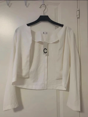 Vit bolerotopp -  Vit bolerotopp med långärmad design och rundad krage