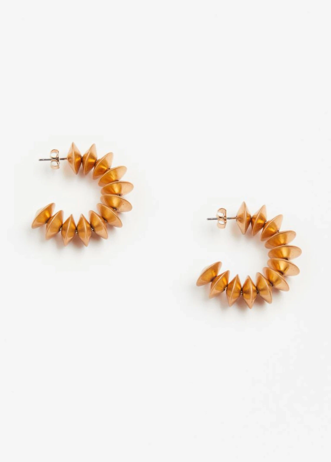 Unika spiralformade örhängen i guldton.