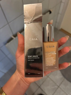 CAIA Dewy Drops Serum Foundation 30N - CAIA Dewy Drops Serum Foundation i nyansen 30N. Kommer i en lyxig frostad glasflaska med silvrig pump och tillhörande metallic-förpackning. Innehåller vitamin E och glycerin för återfuktning och glow. 30 ml, ger en naturlig finish med lätt lyster. Säljer pågrund av att de va fel färg för mig