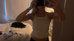 Vit halterneck linnetopp med volanger - Supersöt vit halterneck topp med volangdetaljer och knyt i ryggen. Toppen är ärmlös och har en luftig, lätt känsla som passar perfekt till varma dagar. Snyggt croppad modell med öppen rygg och tunna band som knyts både i nacken och ryggen.