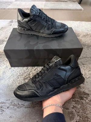 Valentino rockrunner svarta - Valentino rockrunner i en snygg modell! Okej skick. 6/10. Lite missfärgning. Med skor medföljer box och snören också. Storlek 40.5 passar 41