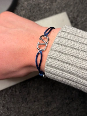 Valentino armband - Säljer ett snyggt och stilrent valentino armband. Armbandet är mörkblått och i mycket fint skick. Tveka inte på att höra av dig!