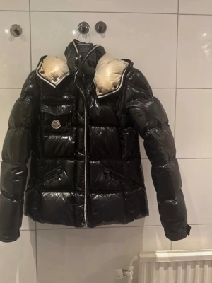 Moncler jacka  - Hej! Jag säljer min fina Moncler-jacka i storlek M/3, tyvärr passar den mig inte längre. • Jackan är äkta, alla bevis ingår. • En dragkedja behöver bytas ut (jag inkluderar en extra dragkedja som kan lagas). • Det finns ett litet hål på insidan som knappt syns. • Priset har sänkts för en snabb försäljning, går inte lägga fler bilder här, kan skicka via här om man undrar något   Mejla mig gärna för bilder eller mer information ❤️