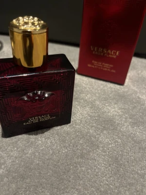 Versace Eros Flame EdP 50ml - Versace Eros Flame Eau de Parfum i en snygg röd flaska med guldiga detaljer. Volym: 50 ml. Ingredienser inkluderar alkohol denat., aqua, limonene, linalool, citral, och flera andra. Perfekt för dig som vill sticka ut med en exklusiv doft.