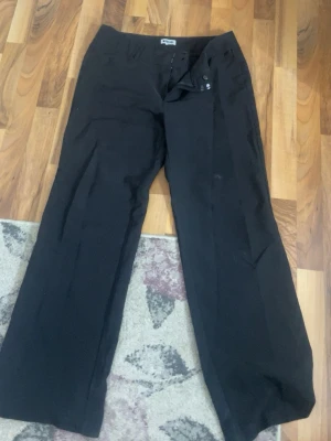 Lågmidjade kostymbyxor från madlady - Svarta Lågmidjade kostymbyxor från madlady i storlek 40 med längden short. De har raka ben och sitter bra på. De passar mig som är 160cm men är lite för långa och då lite slitna där nere vid benen men inget man tänker på. Jag säljer pga att de är lite stora för mig och mest ligger i garderoben. Säljer för 300 då nypriset är ca 650. Skriv privat om ni undrar något eller vill ha bilder på💞