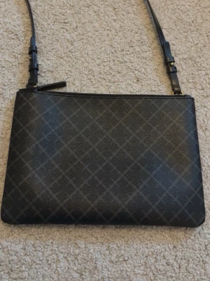 Svart rutig axelväska i skinn - Snygg svart axelväska från malene Birger i grå svart färg, i bra skick💕.