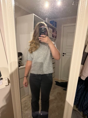 Ljusgrå stickad kortärmad tröja från Gina tricot💞 - Säljer en ljusgrå stickad tröja med korta ärmar. Tröjan har en enkel och clean design med ribbade kanter vid ärmslut och nederkant. Perfekt till jeans eller kjol för en chill och stilren look.