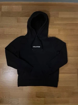 Svart Hollister Hoodie (S) - En svart hollister hoodie i storlek S, fint skick och är en riktig trendig hoodie. Svart och clean passar perfekt för finare och mer slappa dagar! Kom med prisförslag!🎩