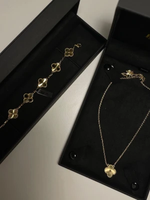  Kejsar smyckeset - halsband & armband  - Säljer ett smyckeset med armband (oanvänt)  och halsband (använt 1 gång) i guldplätering med fyrklöverformade hängen från Kejsar. Mått på halsband: 42+3 cm, Mått på armband: 16-17 cm. Smyckesboxar ingår (som visas i bild) 